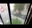 A man swims breaststroke on top of his car during a hail storm