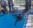 Sacramento police officers swim in uniforms against Grant High School relay team